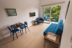 利马索尔Chrielka Hotel的客厅配有蓝色的沙发、桌子和椅子