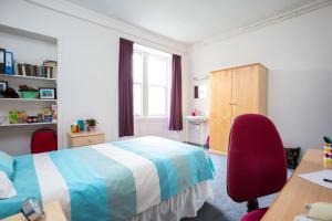 圣安德鲁斯麦金托什大厅校园住宿加早餐旅馆的一间卧室配有一张床、一张书桌和一个窗户。
