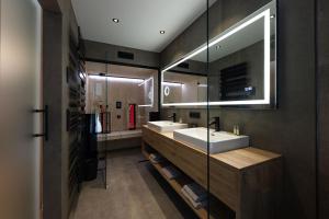 埃本塞Salzkammergut Lodge的一间带两个盥洗盆和大镜子的浴室