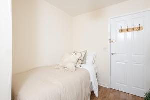 伯明翰Luxury Apartment, Birmingham-Parking的卧室配有带白色床单的床和门。