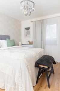 伯明翰Luxury Apartment, Birmingham-Parking的白色卧室配有一张床和一个吊灯