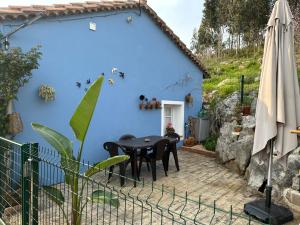 奧瑞那La Casuca del Calero的蓝色的房子,配有黑色的桌子和椅子