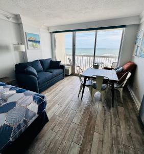 代托纳海滩Daytona Beach Resort Private balcony Ocean Front的客厅设有一张沙发和一张桌子,享有海景。