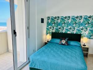 里米尼Residence Frontemare的一间卧室配有蓝色的床罩和蓝色的床罩