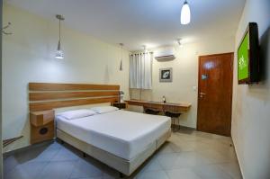 圣保罗Spa Motel - Radial Leste的一间卧室配有一张床、一张书桌和一台电视