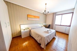 圣塞瓦斯蒂安CASA RURAL BARAZAR的一间卧室配有一张床和一张桌子,上面配有毛巾
