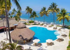 巴亚尔塔港Plaza Pelicanos Club Beach Resort All Inclusive的拥有游泳池、棕榈树和海洋的度假酒店