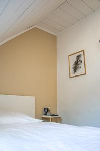 兰施泰因Magaré Hotel & Restaurant的卧室配有白色的床,墙上挂着一幅画