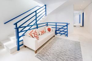 瓜鲁雅Pousada Villa Santô的客厅配有白色沙发和蓝色栏杆