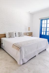 瓜鲁雅Pousada Villa Santô的卧室配有一张白色大床和蓝色门