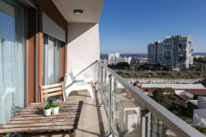 里斯本Lisbon Metro & Pool Apartment的阳台设有木凳,享有城市美景。