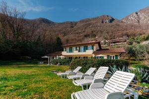 奥利维托拉里奥Villa Oliveto apartments的一排白色草坪椅在房子前面