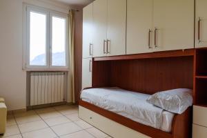 奥利维托拉里奥Villa Oliveto apartments的一间卧室配有一张带白色橱柜的床和窗户。