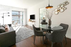 里斯本Lisbon Metro & Pool Apartment的客厅配有玻璃桌和椅子