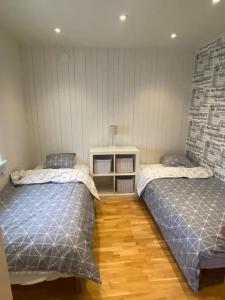 布罗斯Gästhus i Borås (Guest House)的一间卧室设有两张床,铺有木地板