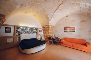 布林迪西La conigliera的客房设有床、沙发和桌子。