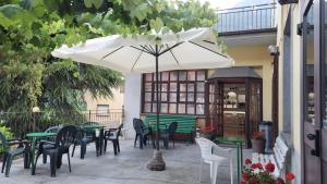 巴切诺Albergo Valentini的一个带桌椅和遮阳伞的庭院