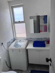萨尔瓦多Apartamento em Amaralina的白色的浴室设有洗衣机和镜子