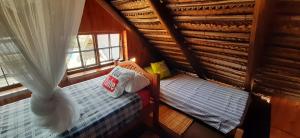MiramarVenha Juntos Guest Homes的阁楼卧室设有两张床和窗户。