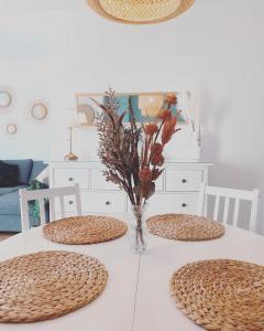 卡门港Casa Rosalia Puerto del Carmen的一张带两把椅子的白色桌子和花瓶
