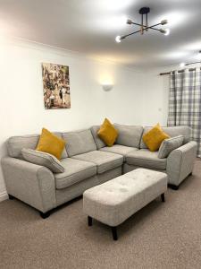 米尔顿凯恩斯Angel view - 4 bed property- perfect for contractors & families的客厅配有灰色的沙发和黄色的枕头。