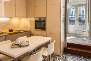 波尔图Cardosas Charming Apartment with Balconies的厨房配有桌椅和窗户。