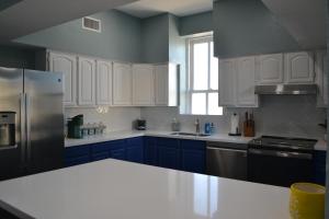 加尔维斯敦The Lofts at GFC的厨房配有蓝色橱柜和白色台面