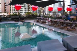 迪拜Lux Studio in Downtown, 5 mins to Burj Khalifa & Dubai Mall - MAG318的一个带桌椅和红色灯笼的游泳池