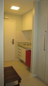 巴西利亚Flat Fusion Setor Hoteleiro Norte com serviço diário de limpeza的一个带水槽和红色橱柜的厨房