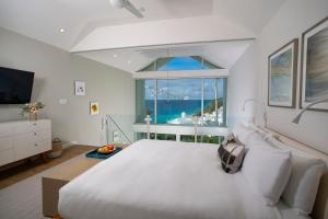 百慕大Azura Bermuda的卧室设有一张白色大床和大窗户
