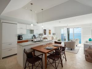 百慕大Azura Bermuda的厨房以及带桌椅的起居室。
