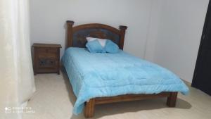 伊萨Villa Alioc的一张带蓝色毯子和床头柜的床