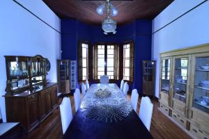 迈普Villa Victoria Lodge的一间设有一张长桌和蓝色墙壁的用餐室
