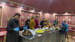 瓦迪拉姆Wadi Rum Khalid luxury camp的站在食物自助餐前的人