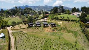 瓜尔内Cumbres Luxury Glamping的享有山丘上带房屋的农场的空中景致