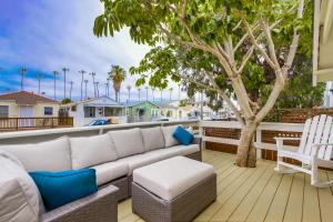 圣地亚哥OB Beach Daze 1的树上甲板上的一张沙发和一把椅子