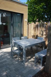 格拉尔-米里茨Ferienhaus Buhne V的野餐桌、两把椅子和长凳