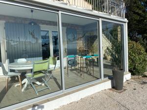 普罗旺斯艾克斯Chez Pat et Dom的温室设有玻璃门和桌椅