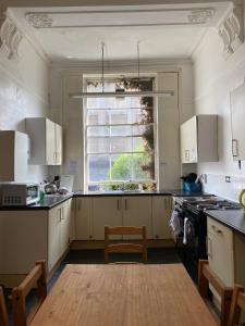 布里斯托Westbourne Place Rooms - by Clifton Short Lets的厨房配有白色橱柜和窗户。