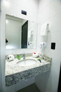 马林加NEO PARK HOTEL的一间带水槽和镜子的浴室
