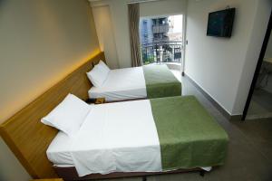 马林加NEO PARK HOTEL的酒店客房设有两张床和窗户。