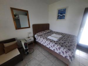 万塔西西TIZA Apartments的一间小卧室,配有一张床和镜子