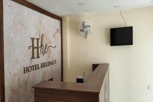 里奥阿查Ayenda Hotel Helenas的酒店客房设有前台和电视。