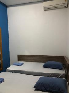 圣保罗Hotel Florêncio的一间卧室配有两张带蓝色枕头的床