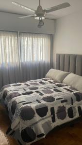 门多萨Departamento en peatonal Mendoza的一间卧室配有一张带牛皮图案毯子的床