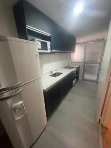 门多萨Departamento en peatonal Mendoza的厨房配有白色冰箱和水槽