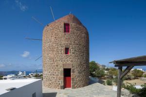 特里皮蒂Marketos Windmill and Houses的大楼顶部有红门的砖塔