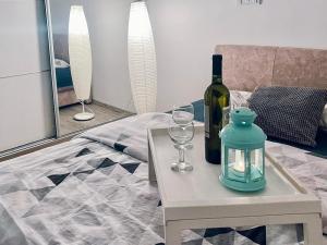 瓦列沃Buba Apartman的一张桌子,上面放着一瓶葡萄酒和眼镜