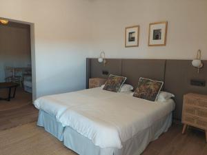 ParejaEl Balcón de la Vega的卧室配有一张带两个枕头的大白色床