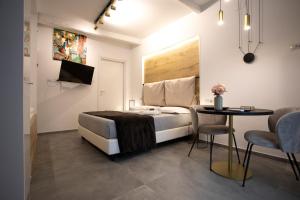巴勒莫LUXURY SUITE SANT ISIDORO的卧室配有一张床和一张桌子及椅子